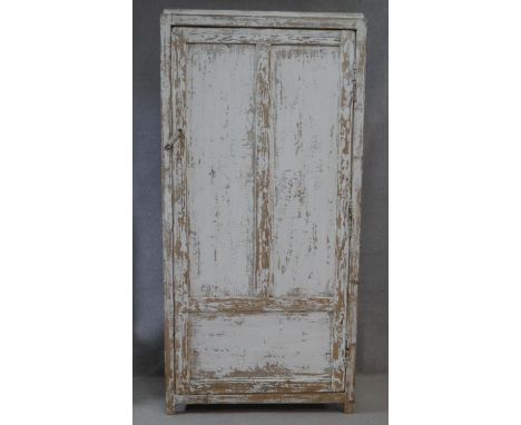 A vintage distressed painted hall cupboard with panel door enclosing linen shelves on block feet. H.194 W.96 D.50cm 