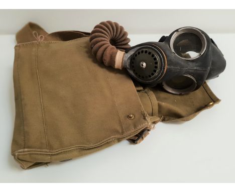 BRITISH ARMY ISSUE GAS MASKwith a black rubber face covering, nozzle and metal filter, with a green canvas carry bag 