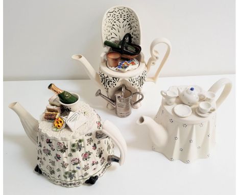 THREE LARGE NOVELTY TEAPOTScomprising one by Portmeirion in the form of a celebratory table, one by The Tea Council Collectio