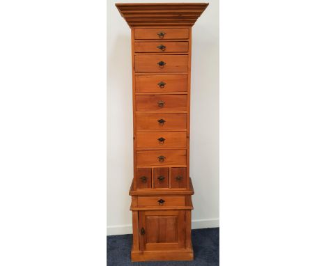 LARGE LIGHT TEAK CHEST with a moulded stepped top above eight graduated drawers and three narrow drawers, the base with a fri