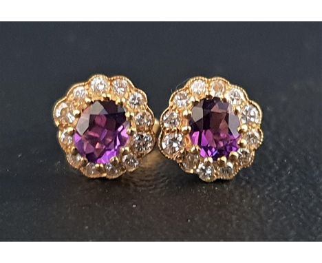 PAIR OF AMETHYST AND DIAMOND CLUSTER EARRINGSeach stud earring with central oval cut amethyst of approximately 0.35cts in twe
