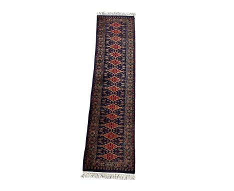 A large vintage hand knotted Kashmir rubber rug. 63x263cm 