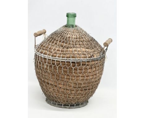 A large vintage wicker and metal bound glass carboy bottle. 44x40x56cm 