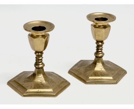 A pair of late 19th/early 20th century brass candlesticks with etched scale and flower motif. 9x10cm 