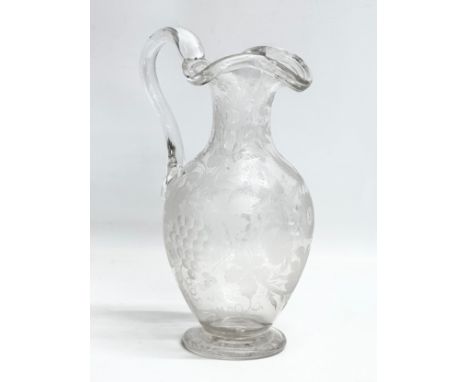 An etched glass pitcher in the manner of William Fritsche. Decorated with leaves, grape vines and birds. 27cm 