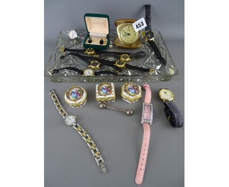 Rectangular glass tray of lady's and gent's watches, three porcelain pillboxes, a folding travel alarm clock etc