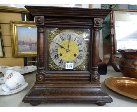 Oak cased bracket clock with Art Nouveau spandrels and silvered dial set with Roman numerals before a pendulum driven gong st