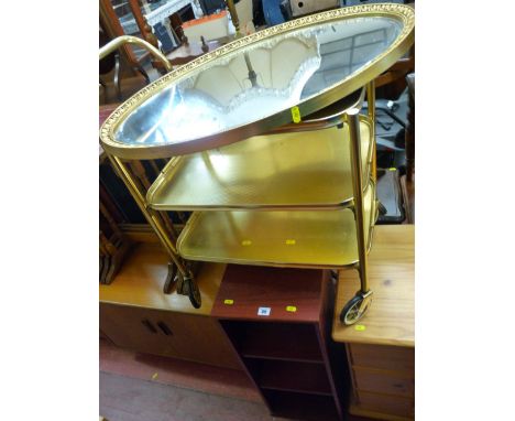 Brass effect three tier trolley, oval gilt framed bevelled edge mirror and two modern CD storage shelves