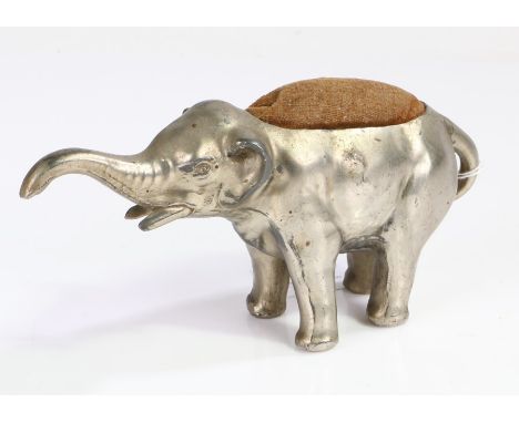 Novelty base metal pin cushion modelled as an elephant with trunk raised, 18cm wide, 9cm high