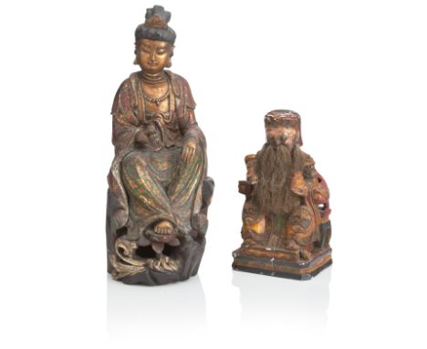 TWO CHINESE POLYCHROME PAINTED HARDWOOD FIGURESLate Qing DynastyThe first Guanyin seated and shown seated on a pierced rocky 