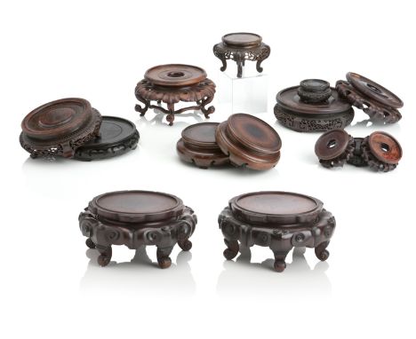 AN IMPRESSIVE PAIR OF CHINESE HARDWOOD STANDSLate Qing DynastyCarved with scrolls and raised on five scroll feet, 29cm diamet