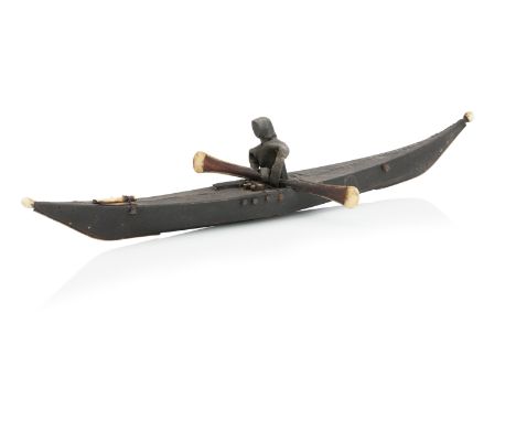AN INUIT LEATHER AND IVORY MODEL OF A FIGURE IN A KAYAKCirca 1900Realistically modelled with a figure holding a paddle,  53cm