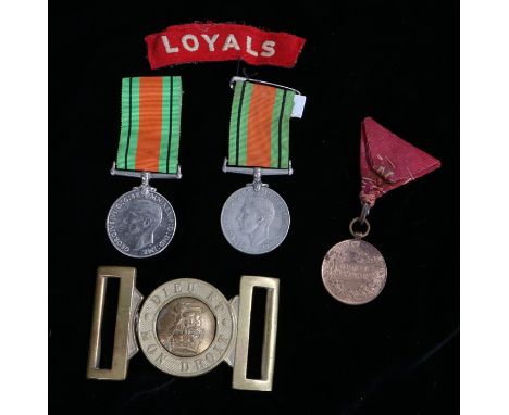 Two Second World War Defence Medals together with an embroidered shoulder title to the Loyals (The Loyal Regiment, North Lanc