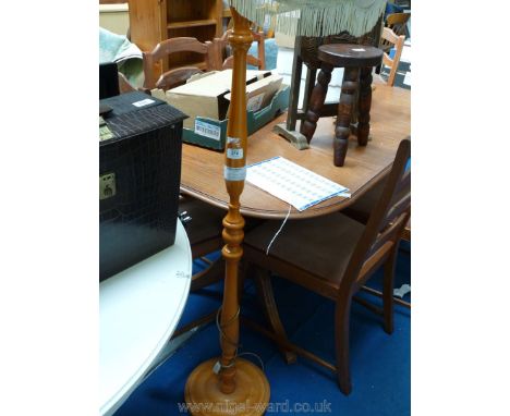 A turned light-wood standard lamp and shade.
