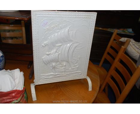 A metal embossed firescreen painted white, galleon detail.