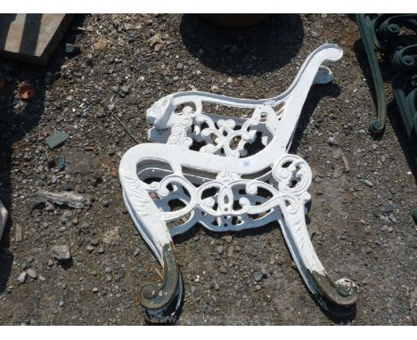 A pair of white painted cast iron bench ends with Lion mask terminating arms.