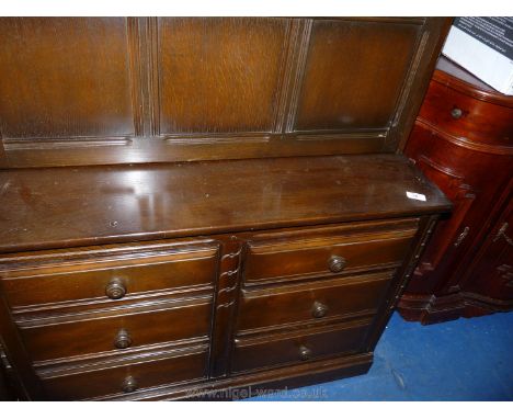 An Ercol dark-wood dresser with drinks compartment shelving and six drawers.
