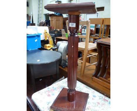 A dark Mahogany plant stand/lamp table with brass feet.