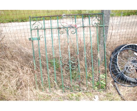 A green wrought iron garden gate.