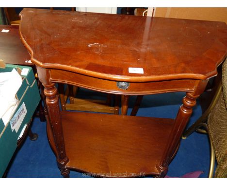 A cross-banded shaped hall table with drawer and lower shelf.