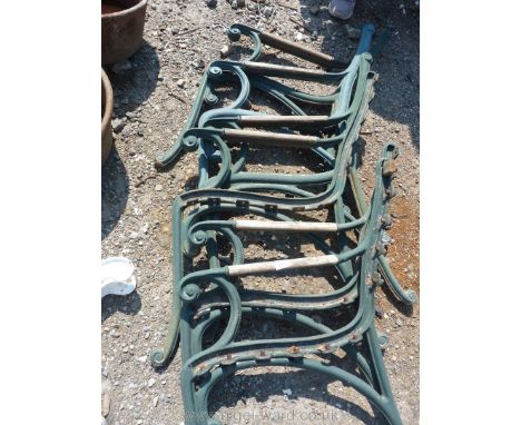  Three pairs of cast iron bench ends with wooden arms.