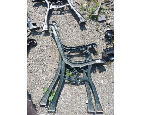 A pair of green painted cast iron bench ends.