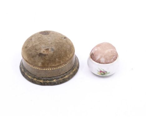 A late 19th century leather banded pin cushion, together with a ceramic cushion (2)