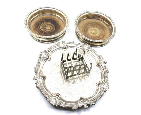 A collection of silver plate, comprising:- two wooden based decanter bottle coasters; a toast rack and a small salver 21.5cm 