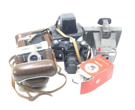 A collection of vintage cameras, comprising:- A zenit-e camera, with leather case; a polaroid 'super swinger' land camera in 