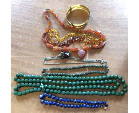 A collection of costume jewellery comprising:- a tortoise shell bracelet; a cornelian necklace; an amber necklace; a green ja