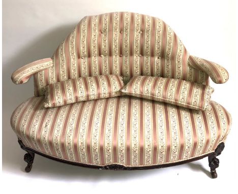 A small Victorian sofa, recently re-upholstered, button shaped back supported on five legs, floral engraved apron, scrolling 