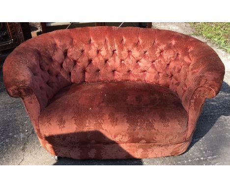 A late 19th century two person button back settee, velvet upholstery (worn) raised on wooden legs terminating in plastic cast