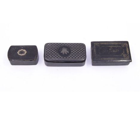 Three snuff boxes, comprising:- a lacquer and pewter inlaid box, a papier mache box with 'Your Health' inlaid on the lid and 