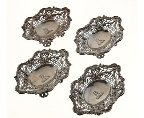 A SET OF FOUR VICTORIAN PIERCED SILVER BONBON DISHES, APPLIED WITH C SCROLLS AND SHELLS, ON PIERCED FLORAL FEET, CRESTED, 14C