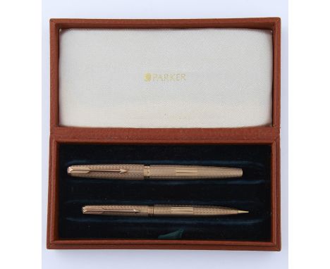 A PARKER 9CT GOLD FOUNTAIN PEN AND PROPELLING PENCIL SET, WAVY ENGINE TURNED, MAKER'S MARK, LONDON 1974,&nbsp; MAKER'S PLUSH 