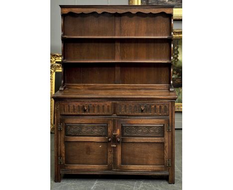 A REPRODUCTION OAK DRESSER IN SHALLOWED CORNICE, SHAPED FRIEZE, SHELVED BACK, THE PROJECTING BASE FITTED PAIR OF FLUTED DRAWE