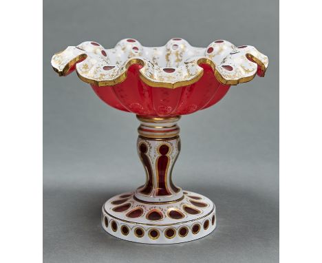 A CASED GLASS COMPORT, C1865, IN RUBY CASED IN WHITE AND GILT, THE DEEPLY LOBED BOWL WITH WAVY TURNOVER RIM, ON WAISTED STEM 