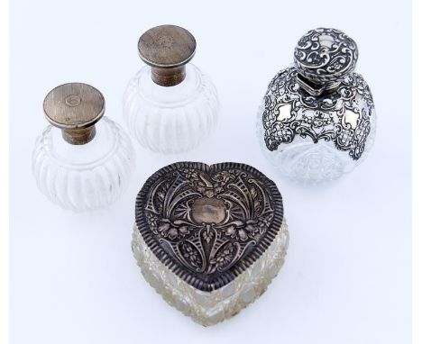 ONE VICTORIAN AND A PAIR OF GEORGE V SILVER MOUNTED CUT GLASS SCENT BOTTLES AND AN EDWARDIAN HEART SHAPED&nbsp; CUT GLASS BOW