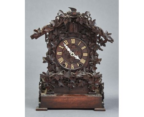 A GERMAN CARVED AND STAINED WOOD CUCKOO CLOCK, LATE 19TH C, OF TYPICAL FORM WITH TILED, PITCHED ROOF AND APPLIED GRAPEVINES S