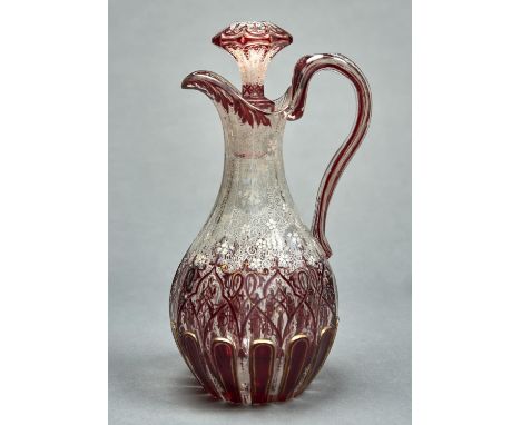 A RUBY FLASHED AND WHITE ENAMELLED GILT GLASS CLARET JUG AND STOPPER, C1860, 29CM H Typical handling wear to gilding, not cra