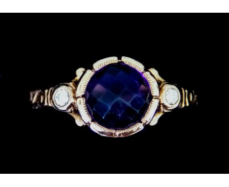 A 9ct Gold Amethyst and Diamond Set Ring, set with a centre faceted amethyst, flanked either side by two small brilliant cut 