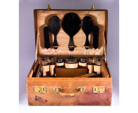 A George V Tan Leather Toilet Case, 20ins x 15ins x 8ins,&nbsp;with seven silver mounted and slice cut glass fitments, mounts