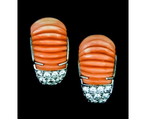 A Pair of Earrings, for non-pierced ears set with splayed coral-coloured material, and each flanked with nine small brilliant