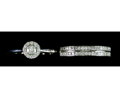 An 18ct Gold Diamond Set Engagement Ring, set with a centre brilliant cut white diamond approximately .15ct, surrounded by sm