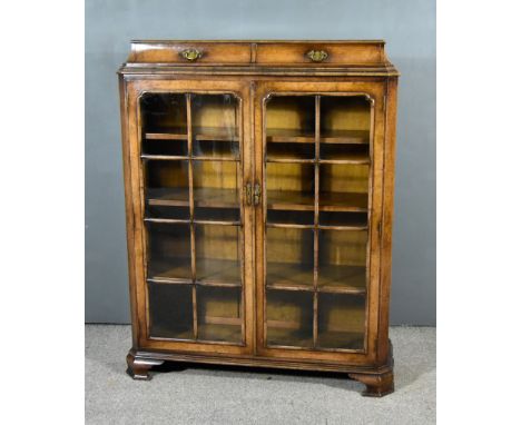 A Walnut Dwarf Bookcase or Display Cabinet of 18th Century Design the shaped top with moulded edge and fitted two drawers, fi