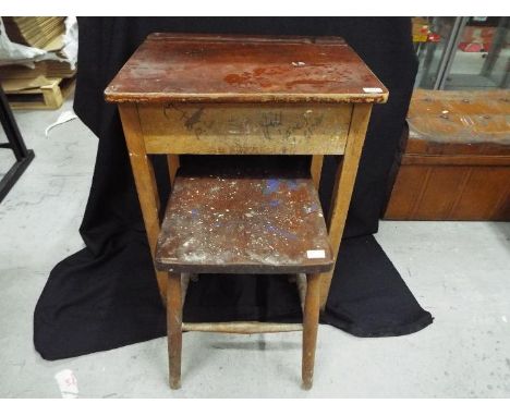 Furniture - A vintage children's wooden school desk and stool with hinged lid, staggered internal shelves and ink well holder