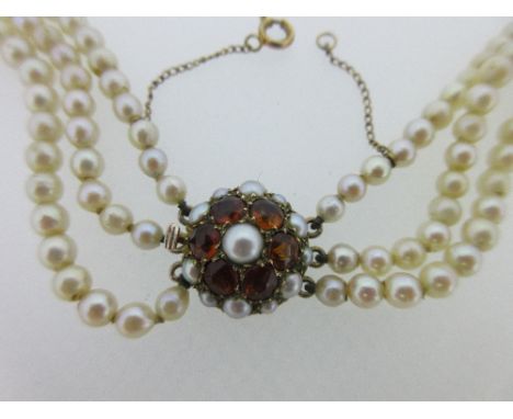 A three row cultured pearl necklace with citrine clasp, the graduated 3.5-7.3mm pearls to a circular clasp stamped '9ct' and 