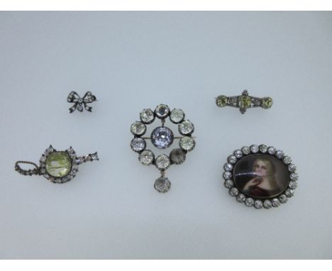 A collection of five 19th century paste set brooches, the first with an oval enamel portrait of a blonde girl looking over he