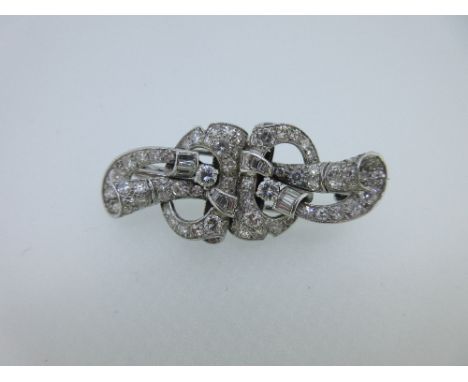 A mid 20th century diamond double clip brooch, the two asymmetrical but identical pieces of pierced, swirling and curling des