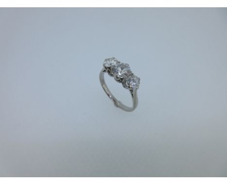 A three stone diamond ring, the graduated round brilliant cut diamonds claw set to a coronet gallery with a plain tapered sha
